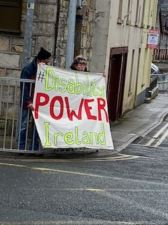 Disability Power Ireland Protest in Leitrim Two people holding a sign that reads '#Disability POWER Ireland' on a street corner